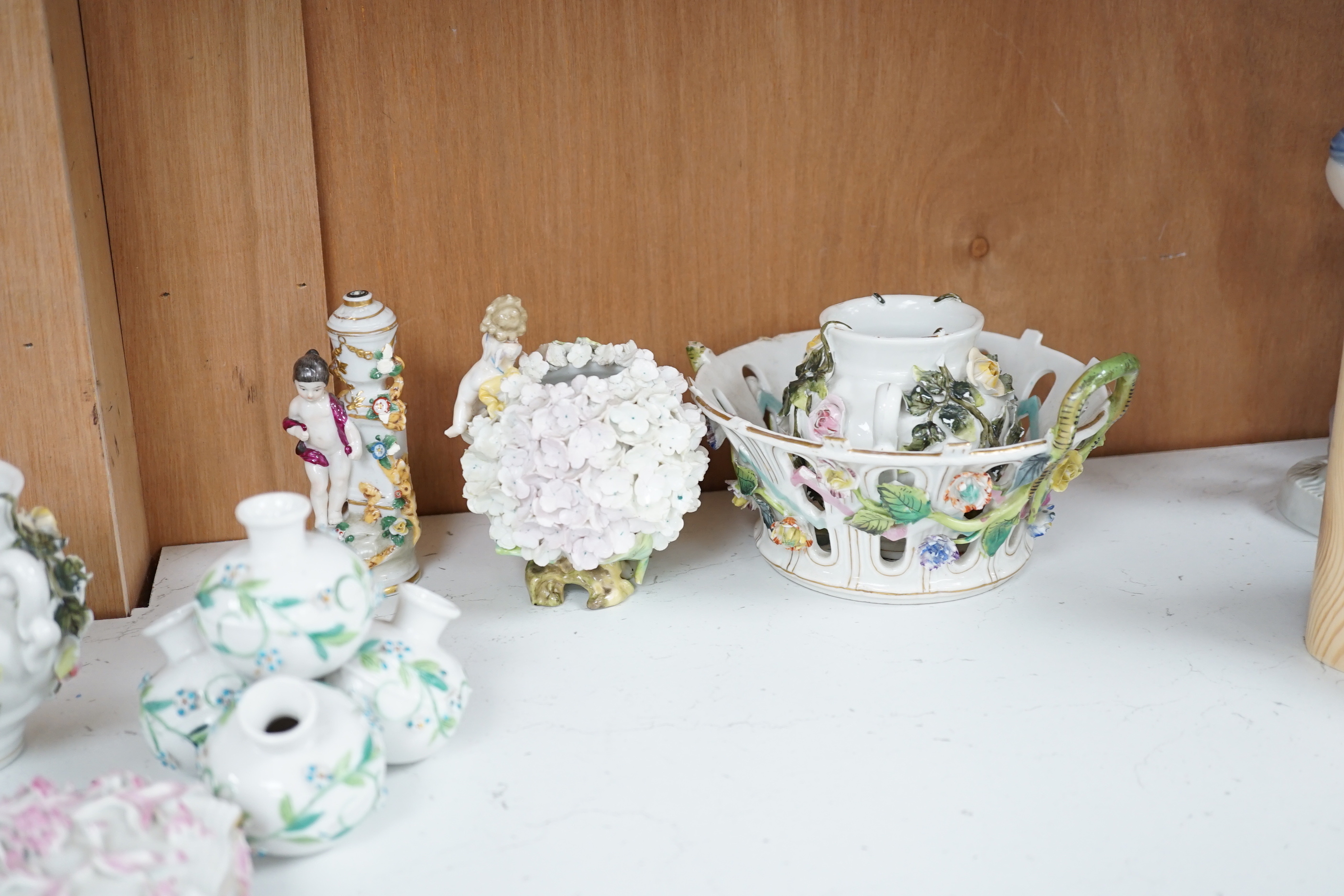 A group of German flower encrusted tableware, including a matched Meissen cup and saucer, lidded box, salts, figures, etc., tallest figure 12cm